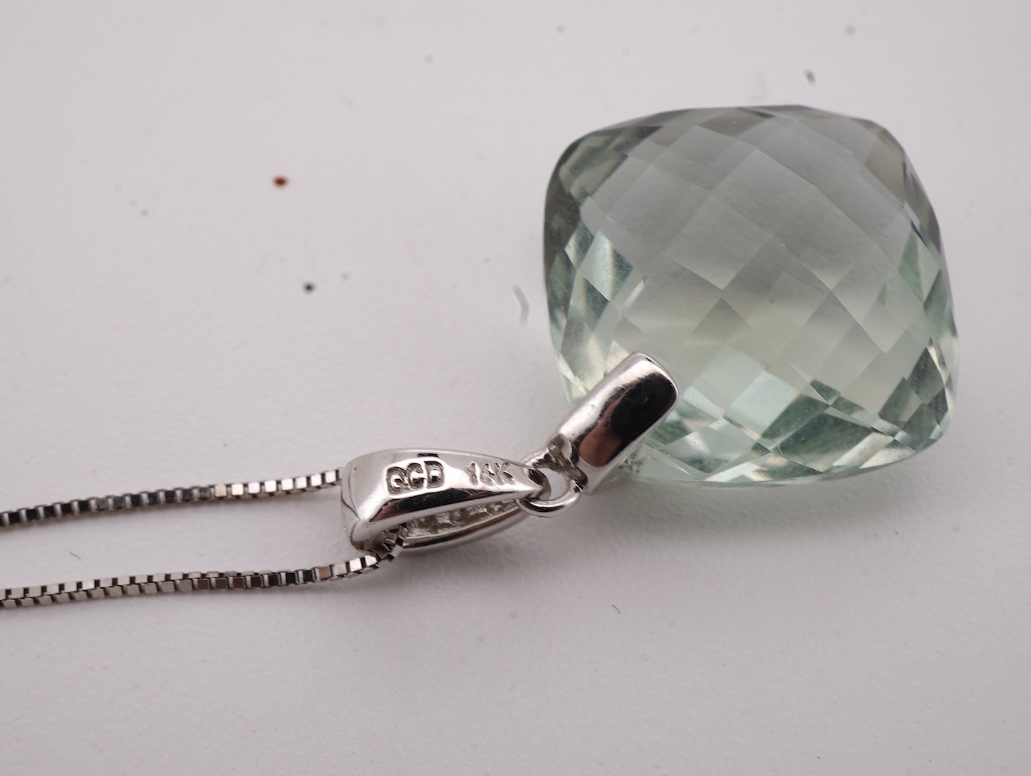 A prasiolite and diamond pendant, the diamond-set bail suspending a cushion-shaped chequerboard-cut prasiolite, to a fine link chain, mounted in 14ct gold, pendant length 2.5cm, chain length 46cm, British hallmarks, gros